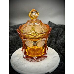 Fostoria Coin Glass amber candy dish with a lid.